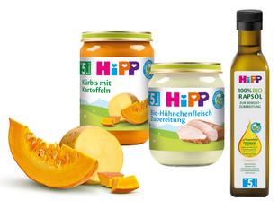 Eine Reihe von Babynahrungsprodukten der Marke "Hipp", darunter Gläser mit Kürbis- und Süßkartoffelpüree, ein Glas mit Babynahrung auf Truthahnbasis und eine Flasche mit Rapsöl.