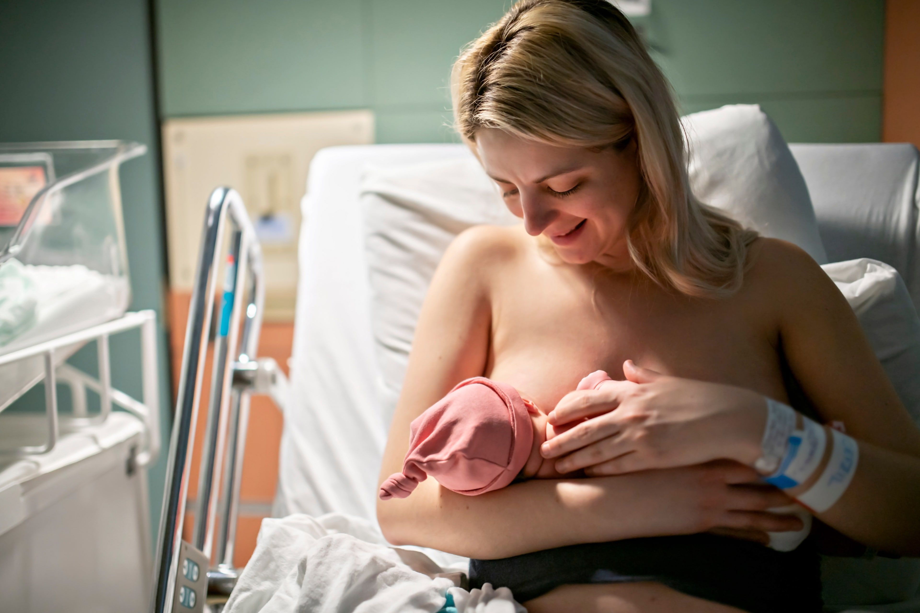 Ein zärtlicher Moment zwischen einer Mutter und ihrem neugeborenen Baby in einem Krankenhaus.