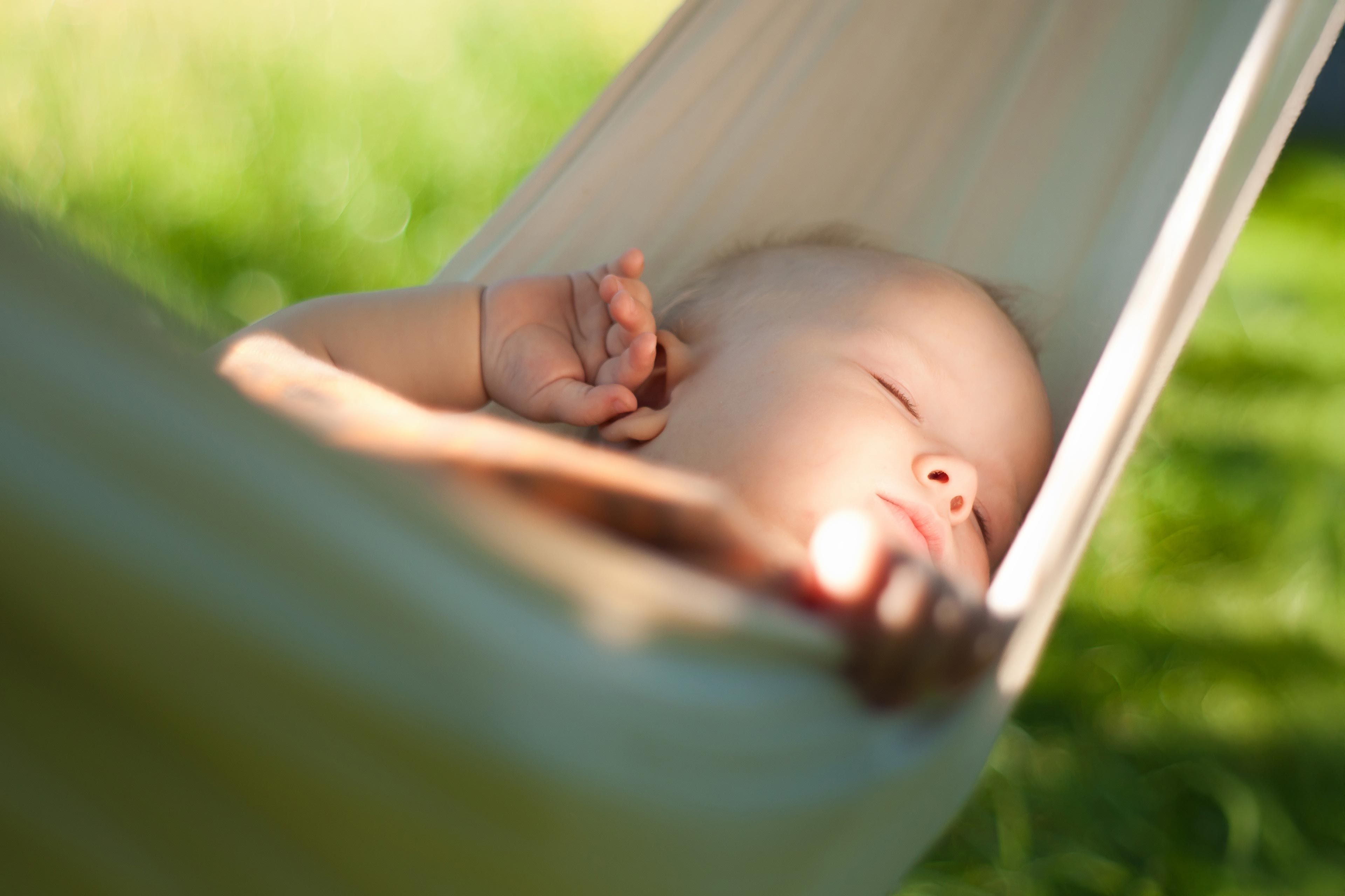 Baby liegt entspannt in einer Hängematte im Freien