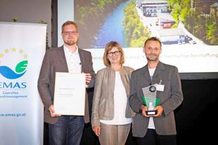 Bundesministerin Maria Patek überreicht Vertretern des HiPP Standorts Gmunden den Umweltmanagement-Preis 2019 auf einer Bühne.