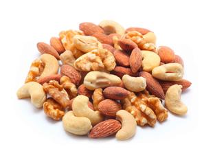 Eine Vielzahl von Nüssen, darunter Mandeln, Walnüsse und Cashews, die auf einem Haufen angeordnet sind.