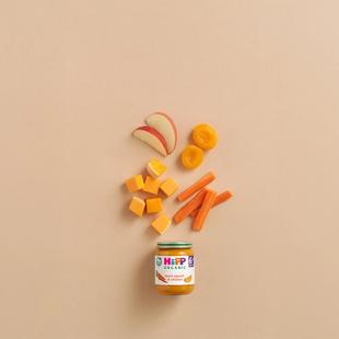 HiPP Organic Sweet Squash & Chicken baby food jar with apple slices, apricot halves, squash cubes and carrot sticks on a neutral background