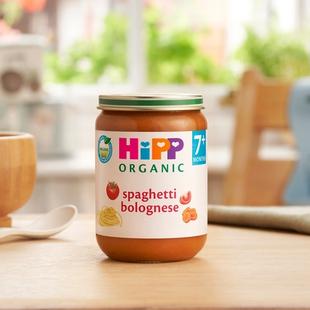 HiPP Organic Spaghetti Bolognese on a dining table next to a bowl and spoon