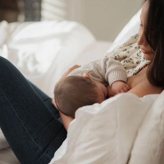 Mum breastfeeding baby in bed