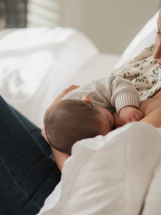 Mum breastfeeding baby in bed