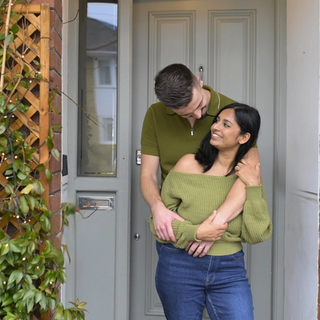 A couple hugging in front doorway