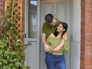 A couple hugging in front doorway