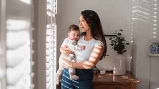 Mum holding a baby by the window