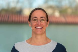 Christina, freundlich lächelnde Wissenschaftlerin im HiPP Muttermilchforschungsteam, Porträt vor unscharfem Hintergrund
