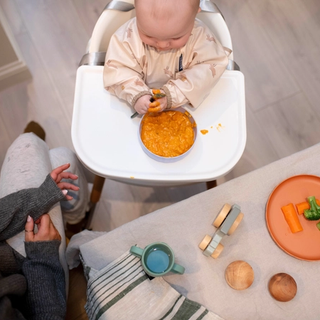 Baby eating at table with mum