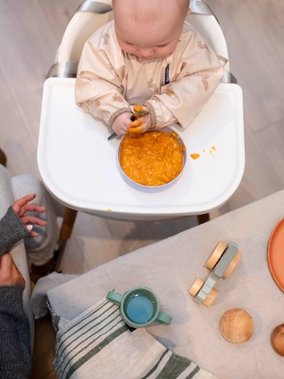 Baby eating at table with mum