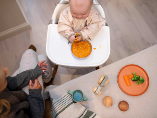 Baby eating at table with mum