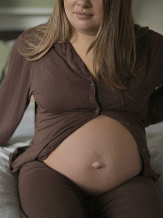 Pregnant woman holding back