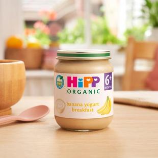HiPP Organic Banana Yogurt Breakfast jar on a dining table next to a bowl and spoon