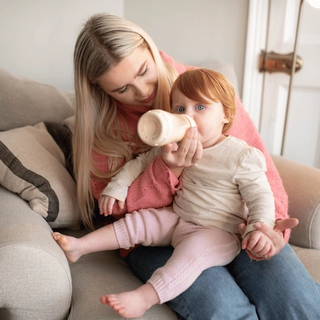 Mum giving her toddler a bottle