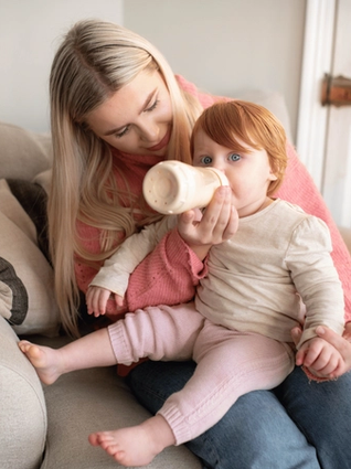 Mum giving her toddler a bottle
