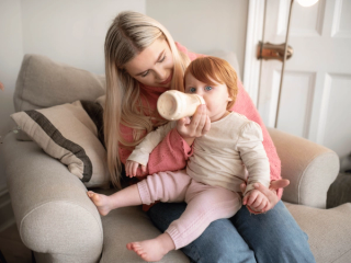 Mum giving her toddler a bottle