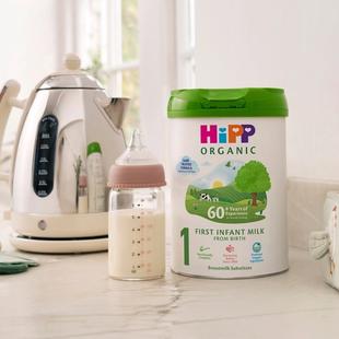 HiPP Organic First Infant Milk Powder Tin on a kitchen worktop next to a bottle of milk