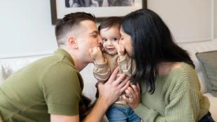 Mum and dad kissing baby's cheeks