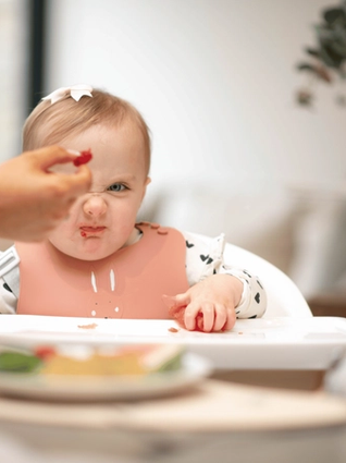 Baby scowling at raspberry