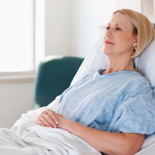 Ruhende Patientin im Krankenhausbett, entspannt liegend, symbolisiert verschiedene Krankheitsbilder und einfühlsame medizinische Betreuung.