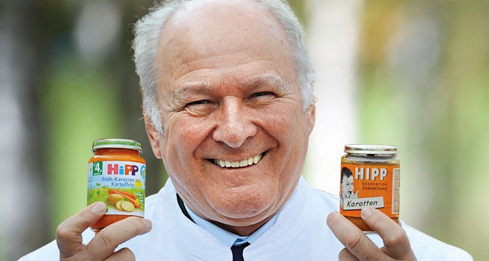 Claus Hipp hält zwei Gläschen HiPP-Babynahrung in den Händen