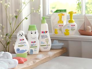 HiPP Baby Care range of products on a shelf over a bath and on a window sill