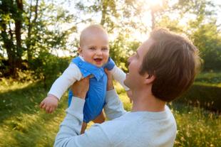 Vater hält Baby im Freien bei Sonnenlicht