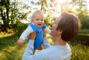 Vater hält Baby im Freien bei Sonnenlicht