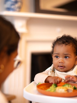 Mum feeding baby in highchair