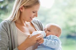 Eine Frau füttert ihr Baby mit der Flasche.