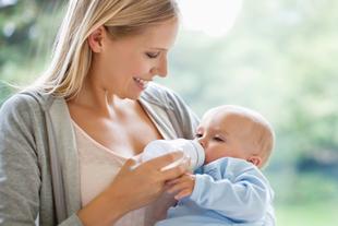 Eine Frau füttert ihr Baby mit der Flasche.