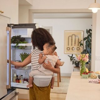 Mum carrying toddler on hip pad.