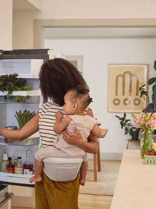 Mum carrying toddler on hip pad.