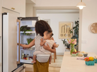 Mum carrying toddler on hip pad.