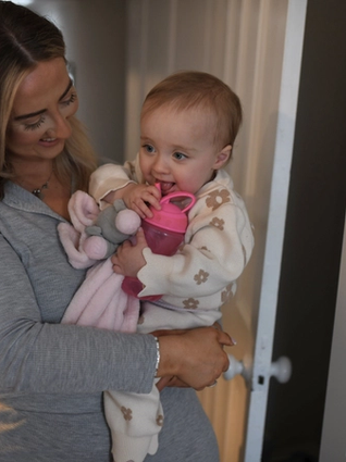 Mum smiling at her baby whilst carrying her
