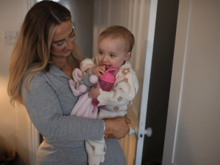 Mum smiling at her baby whilst carrying her