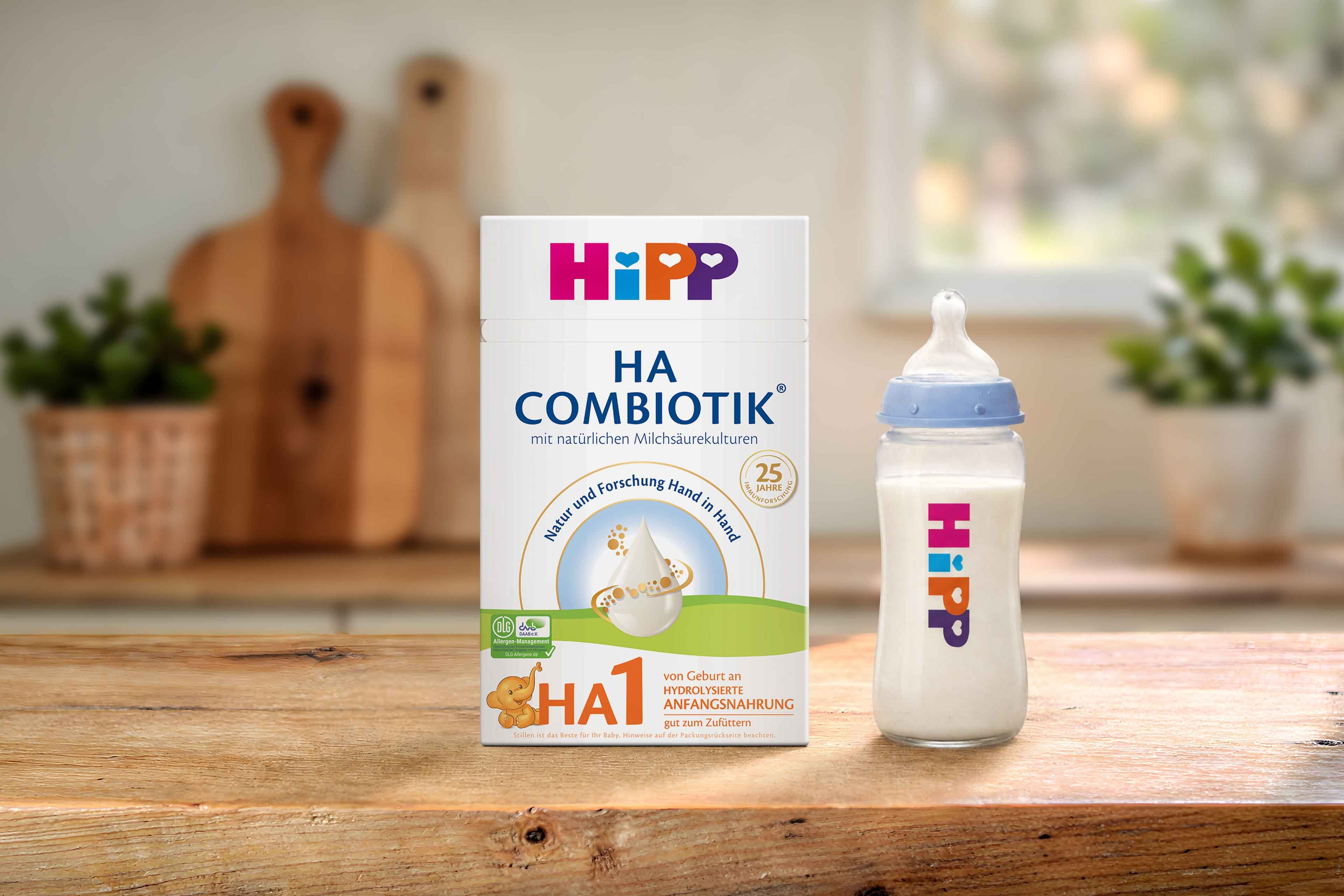 HiPP HA COMBIOTIK® HA 1 Anfangsnahrung Packung mit Babyflasche auf Holztisch in heller Küche