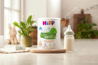 HiPP anti-reflux milk powder tin next to a milk bottle on a kitchen worktop
