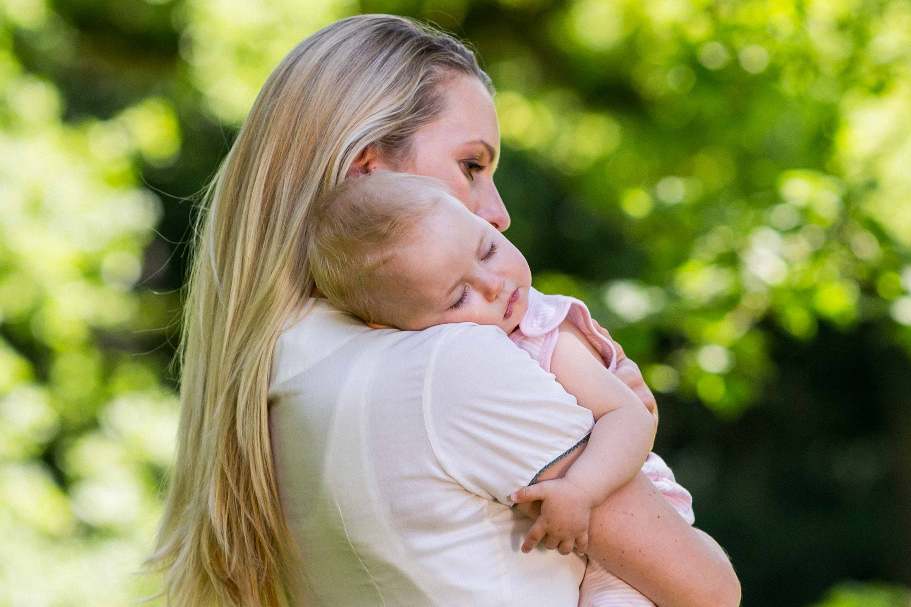 Eine Mutter hält ihr schlafendes Baby auf dem Arm