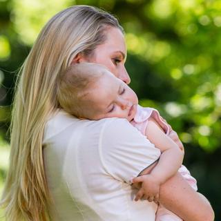 Eine Mutter hält ihr schlafendes Baby auf dem Arm