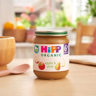 HiPP Organic Apple & Pear jar on a dining table next to a bowl and spoon