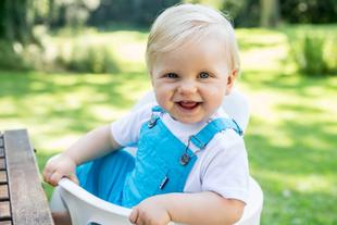 Ein lächelndes Baby sitzt in einem Hochstuhl