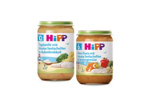 Zwei Gläschen Babynahrung mit der Aufschrift "Hipp", die jeweils ein Gericht mit Spaghetti mit Alaska-Meeresfrüchten und Butterkekssoße enthalten.