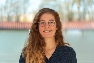 Julia, freundlich lächelnde Ernährungswissenschaftlerin im HiPP Muttermilchforschungsteam, Porträt vor unscharfem Hintergrund