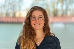 Julia, freundlich lächelnde Ernährungswissenschaftlerin im HiPP Muttermilchforschungsteam, Porträt vor unscharfem Hintergrund