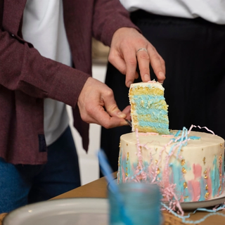 Gender reveal cake being cut to reveal blue icing