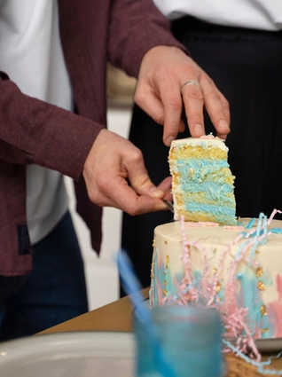 Gender reveal cake being cut to reveal blue icing