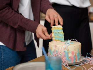 Gender reveal cake being cut to reveal blue icing