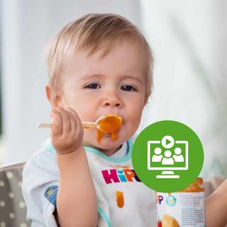 Baby sitzt im Hochstuhl, isst orangefarbenen Brei mit dem Löffel und trägt ein HiPP-Lätzchen, Symbol fürs Beikost-Webinar davor.